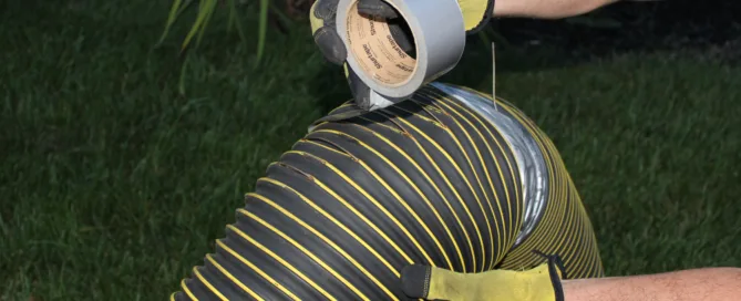 photo of a ripped leaf vacuum hose being repaired with duct tape